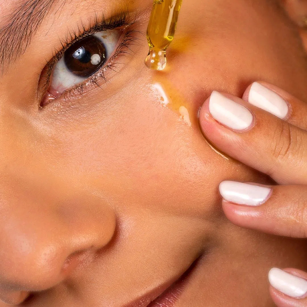 Femme qui utilise sur son visage l'huile de noisette anti imperfection de Oden avec une pipette