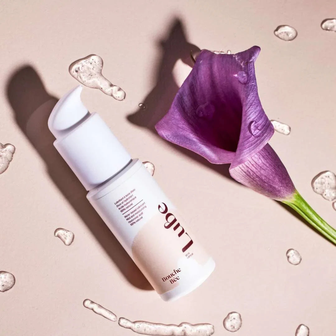 Lubrifiant Lube de Bouche Bée avec texture sur fond et une fleur à côté - Gapianne