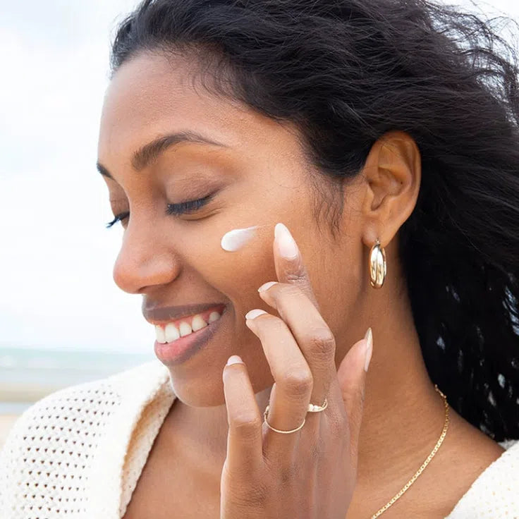 Femme qui s'applique de la crème soin pour visage pour période pré-menstruelle Oh my periods de Nidéco