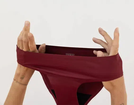 culotte de règle carmin smoon tenue entre 2 mains, douce, confortable, sans odeur, 12h de protection