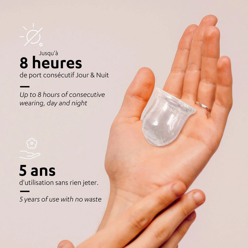 Une main tient une coupe menstruelle lunéale