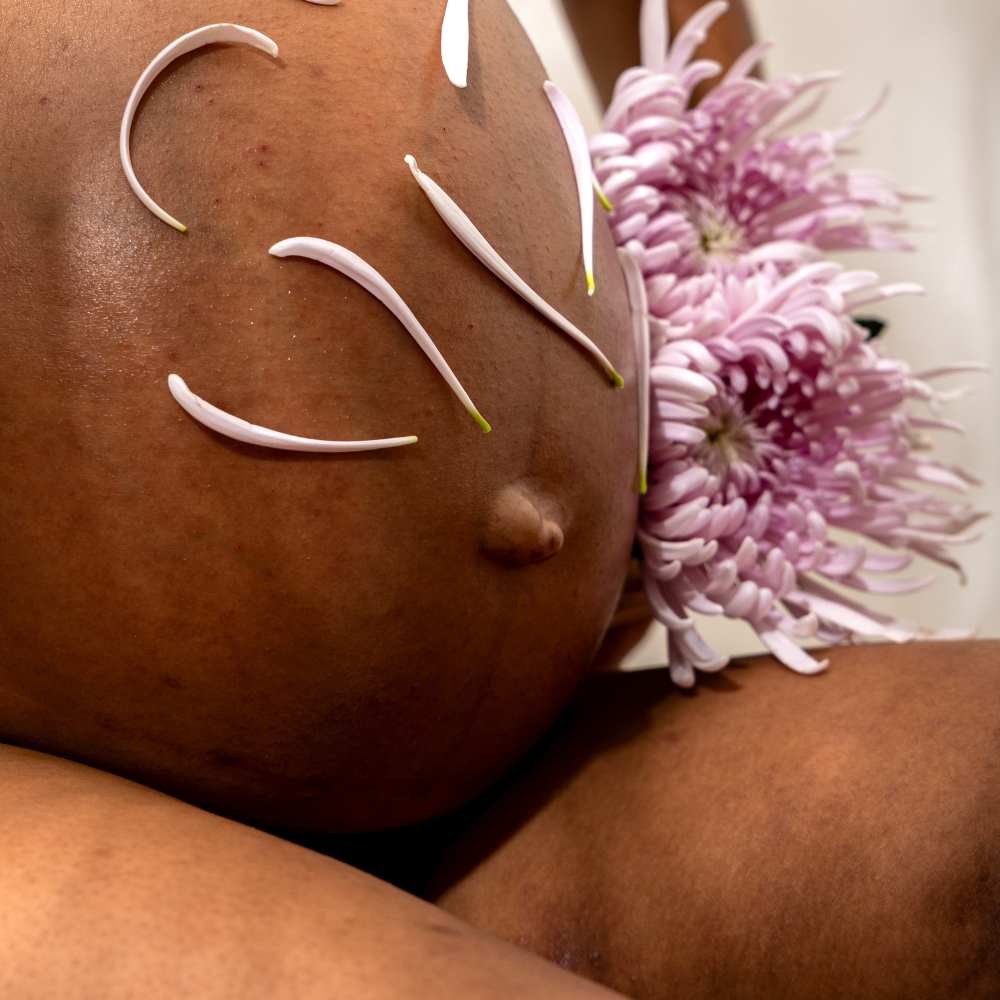 ventre femme enceinte avec pétales de fleurs posées dessus gapianne fertilité