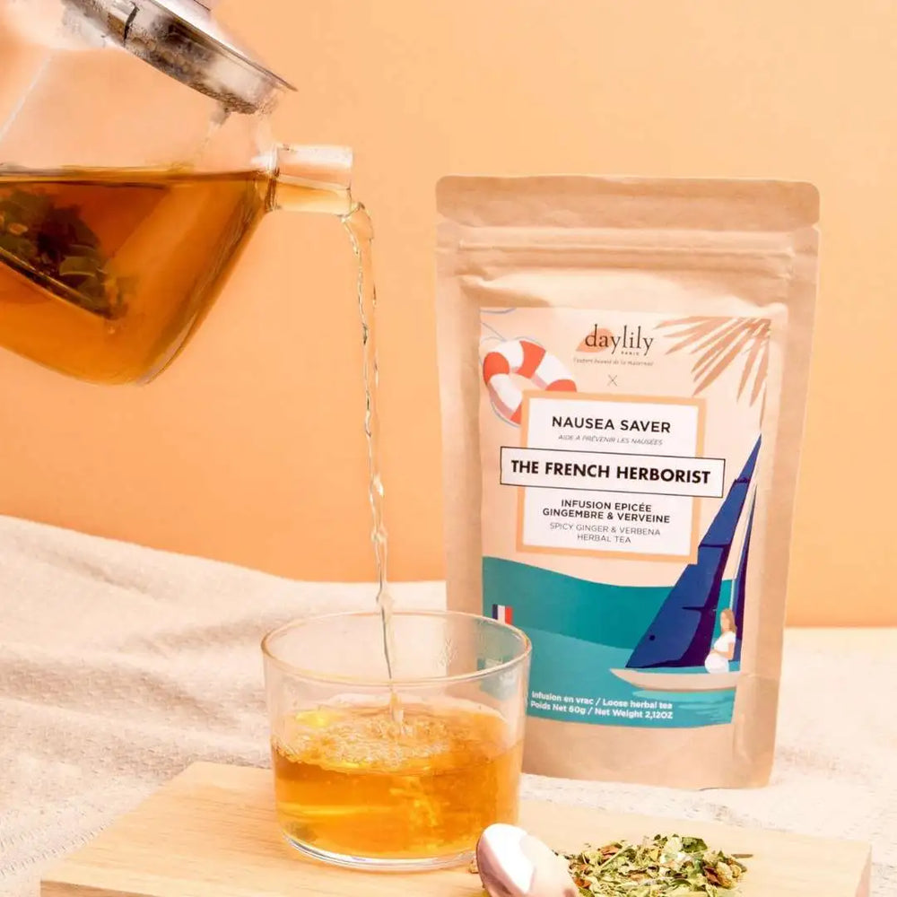 Théière qui verse la tisane anti nausées The French Herborist x Daylily dans un verre et son paquet à côté - Gapianne
